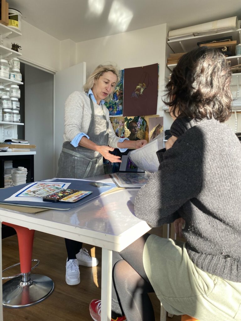 Dans son atelier, Laurence Brecher présente ses maquettes à sa cliente pour son projet de crédence de cuisine