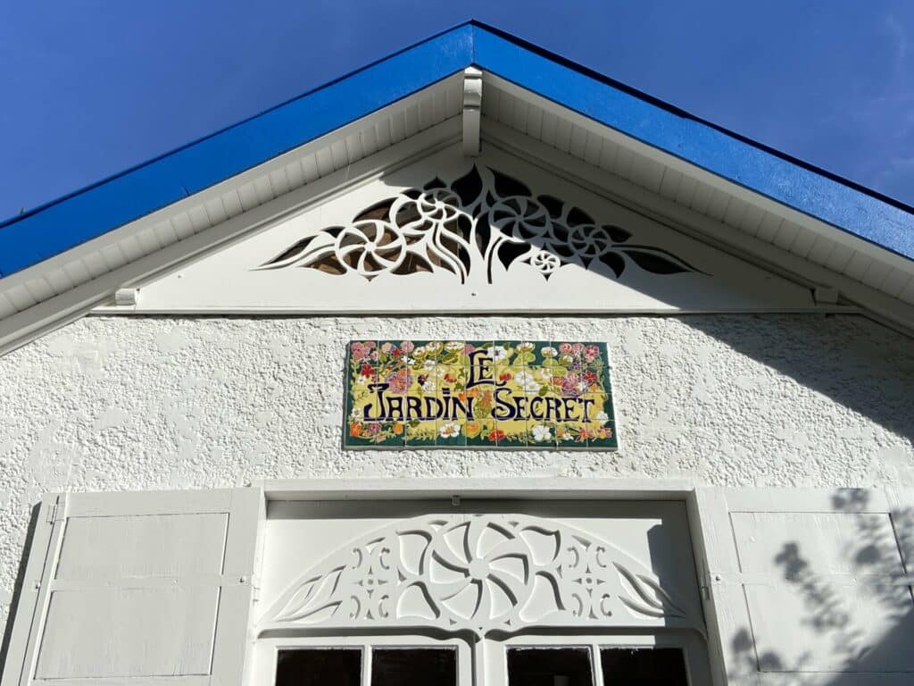 Fronton de villa avec plaque nominative en céramique murale sous toit triangulaire bleu