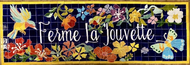 Enseigne céramique Ferme La Jouvette, lettrage blanc et fleurs sur fond bleu nuit