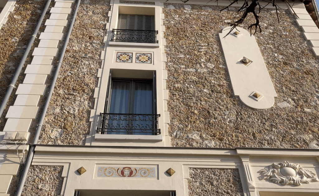Décors en céramique restitués sur une façade en meulière à Versailles : frise peinte et cabochons
