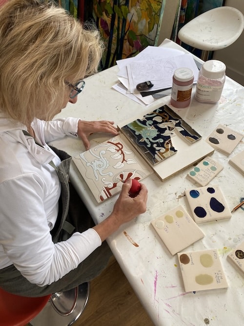 Laurence Brecher peint un carreau de céramique Art Nouveau dans son atelier du Vésinet