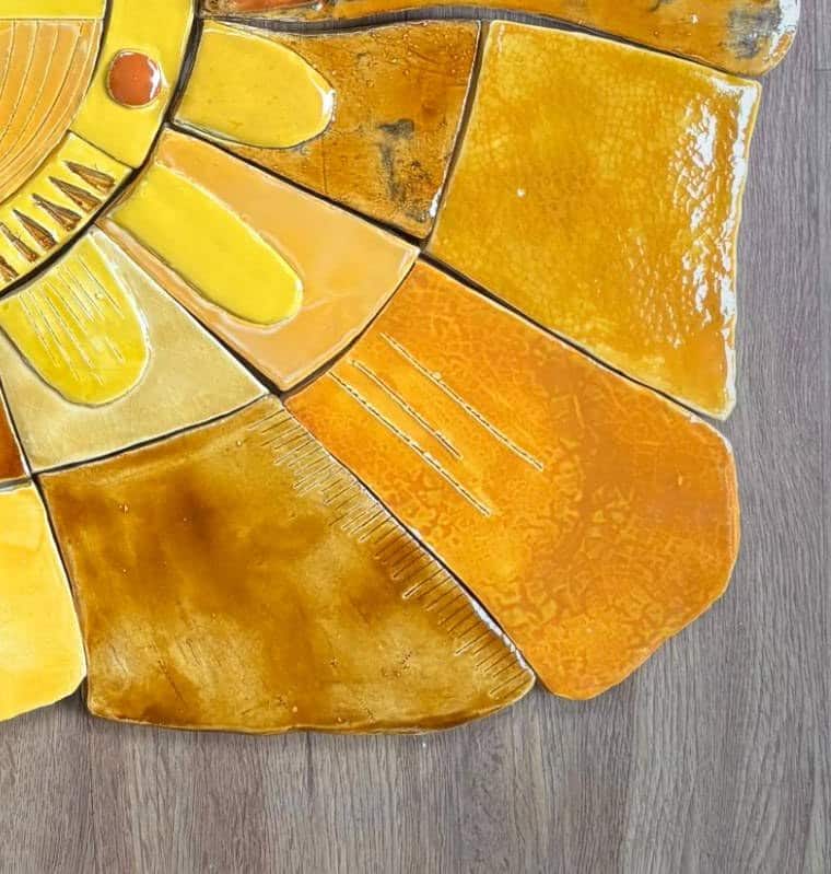 Rayons du soleil en céramique : lignes gravées, bords dentelés et fin craquelé de l'émail orangé